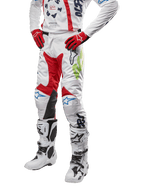 Alpinestars 2024 Racer Hana broek, motorcross racebroek, wit met rode, blauwe en limoengroene accenten, beschermend ontwerp met leren kniepanelen, gedragen met bijpassende jersey, rode handschoenen en witte laarzen met gespen, sportieve motorsportoutfit