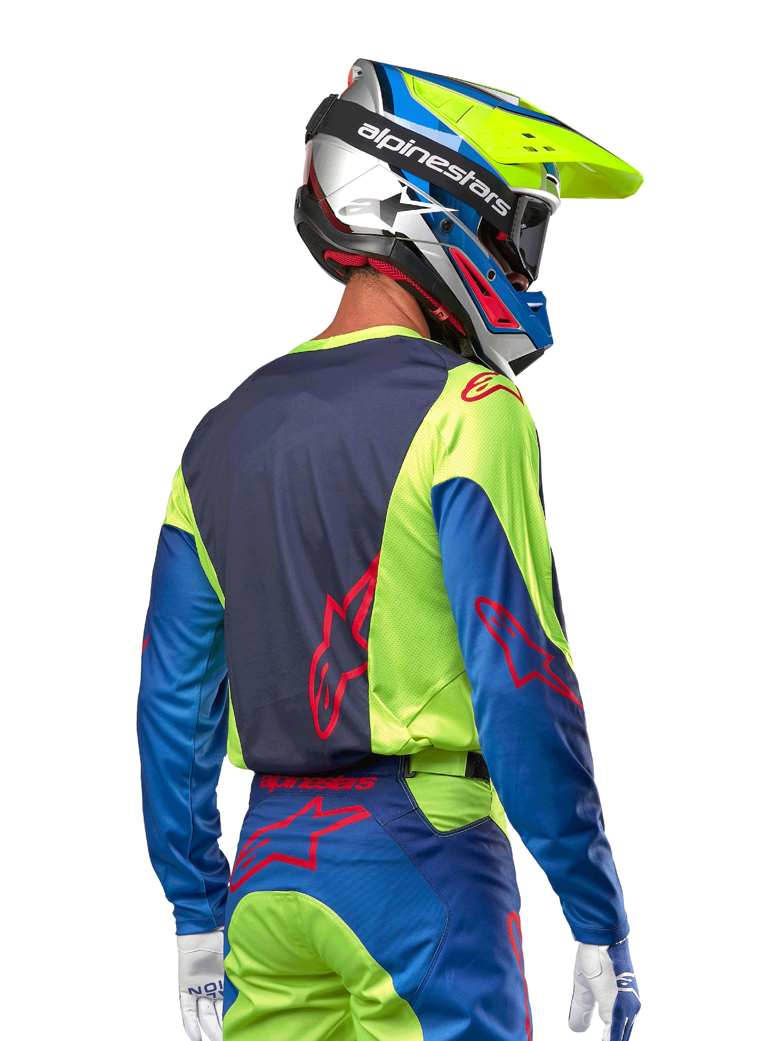Motorcrosser in de Alpinestars 2024 Racer Hoen Jersey in Yellow Fluo en Blue Night Navy, met een rood sterlogo op de rug, bijpassende motorcrossbroek en een gecoördineerde helm, achteraanzicht dat het ergonomische ontwerp voor off-road prestaties toont.