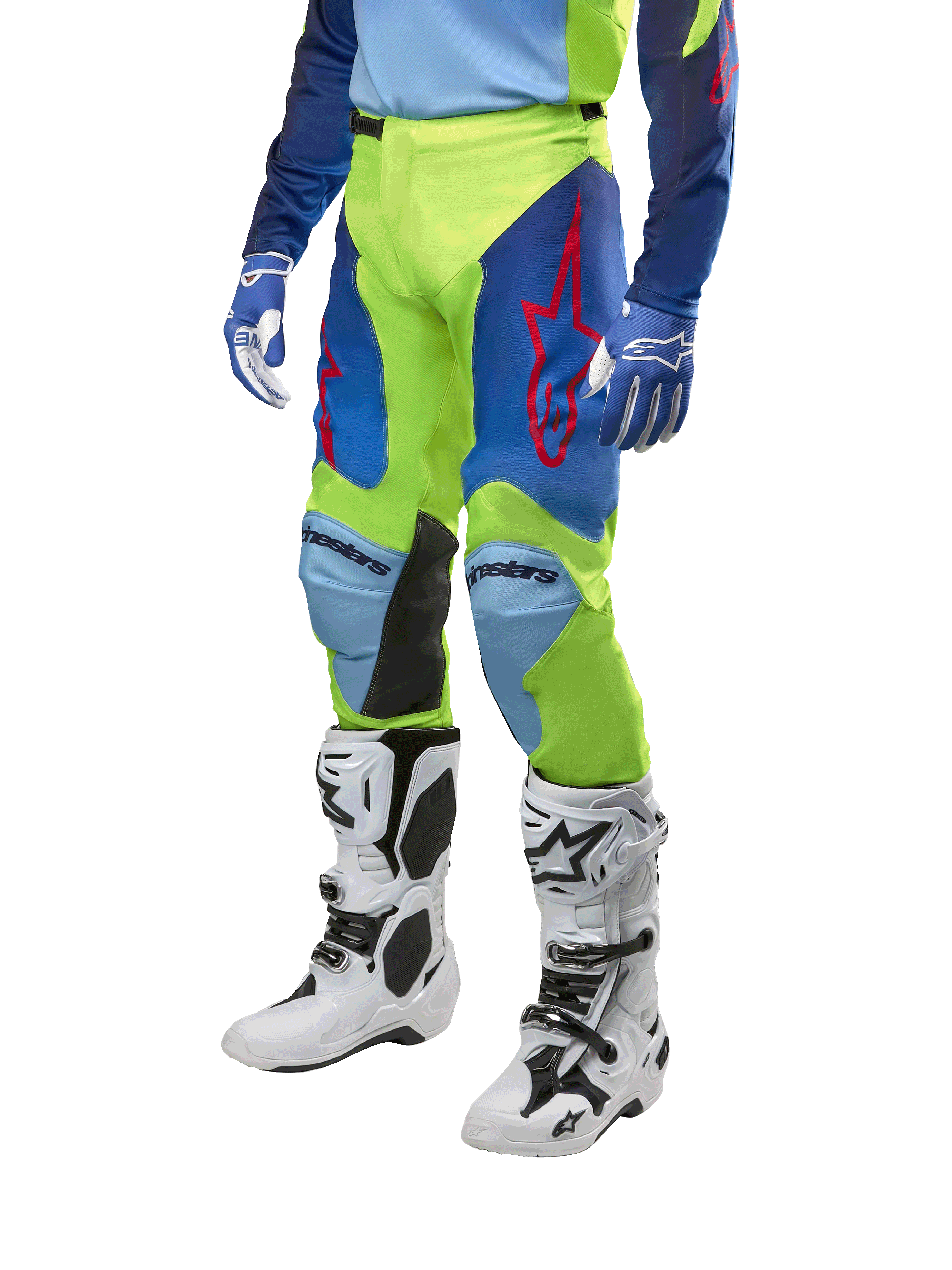 Alpinestars 2024 Racer Hoen broek, motorcrossbroek, fluogeel en donkerblauw, voorzien van rode sterlogo's en zwarte panelen aan de binnenkant van de knieën, gedragen met een bijpassende jersey en witte motorcrosslaarzen, technische uitrusting voor off-road racen
