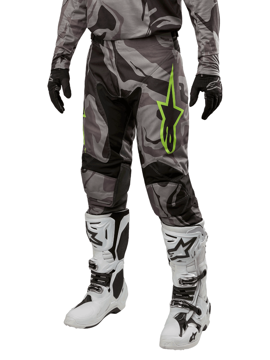 Alpinestars 2024 Racer Tactical broek, motorcrossbroek, grijs en zwart camouflagepatroon, limoengroen sterlogo, gedragen met witte en zwarte laarzen en zwarte handschoenen, off-road motoruitrusting
