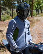 Motorrijder die de Alpinestars Chrome Air Sport Hoodie in grijs gemêleerd draagt, met limoengroene mesh zijpanelen en zwarte logo's, gecombineerd met een zwarte carbon fiber helm en zwarte handschoenen, zittend op een Ducati motor op de weg in een buitenomgeving