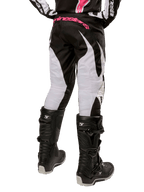 Alpinestars Stella 2024 Fluid dames motorcrossbroek, zwart en wit, achteraanzicht met witte beenpanelen en roze logo op de tailleband, gedragen met zwarte Tech 3-laarzen, duurzame uitrusting voor off-road racen