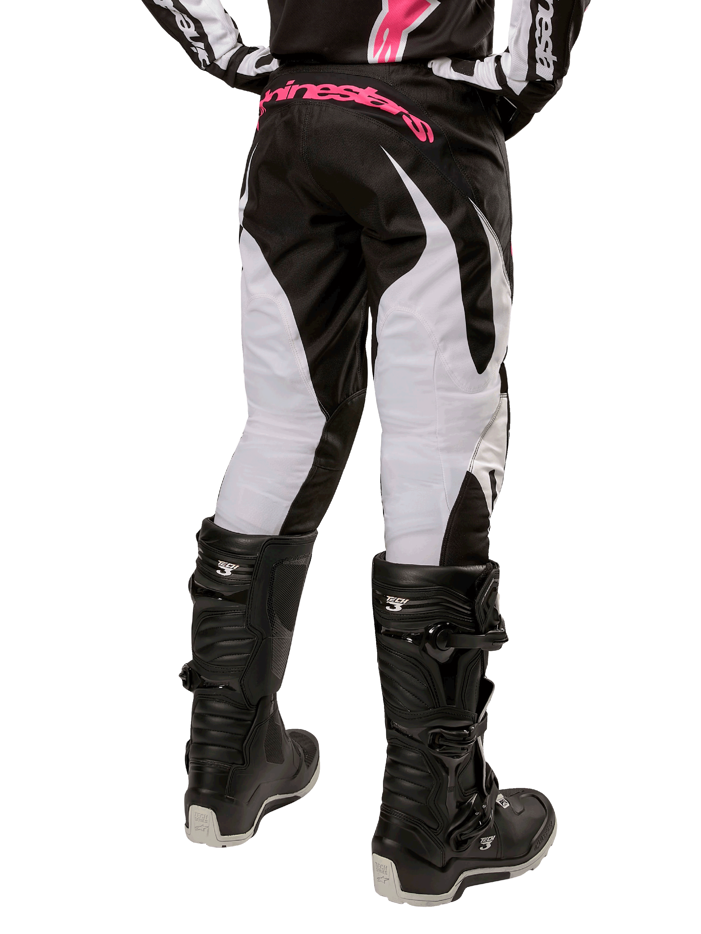 Alpinestars Stella 2024 Fluid dames motorcrossbroek, zwart en wit, achteraanzicht met witte beenpanelen en roze logo op de tailleband, gedragen met zwarte Tech 3-laarzen, duurzame uitrusting voor off-road racen