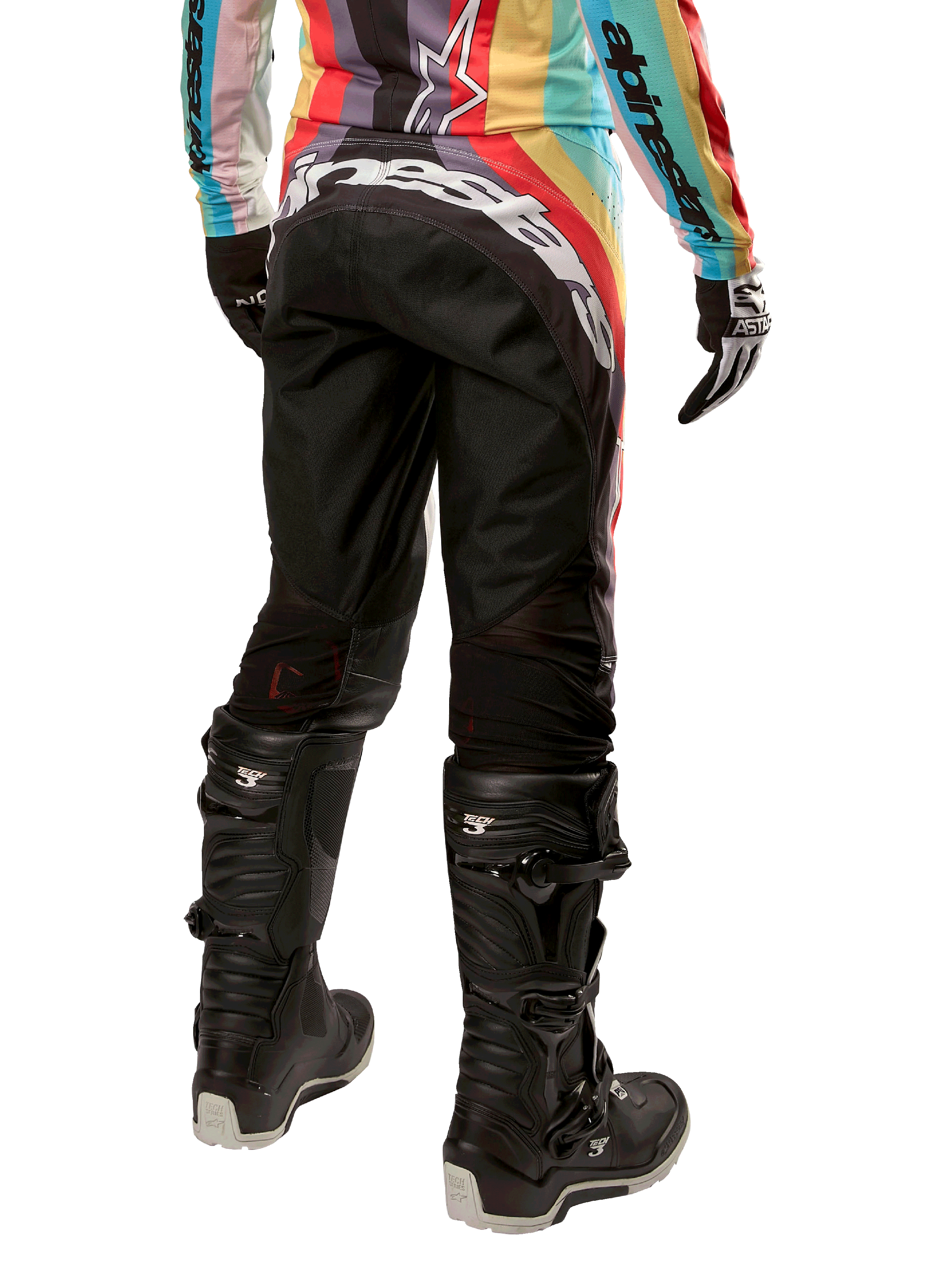 Alpinestars Stella 2024 Techstar dames motorcrossbroek, zwart multicolor, achteraanzicht met opvallende witte branding op het zitvlak, gedragen met zwarte Tech 3-laarzen en een bijpassende multicolor jersey, professionele off-road racekleding.