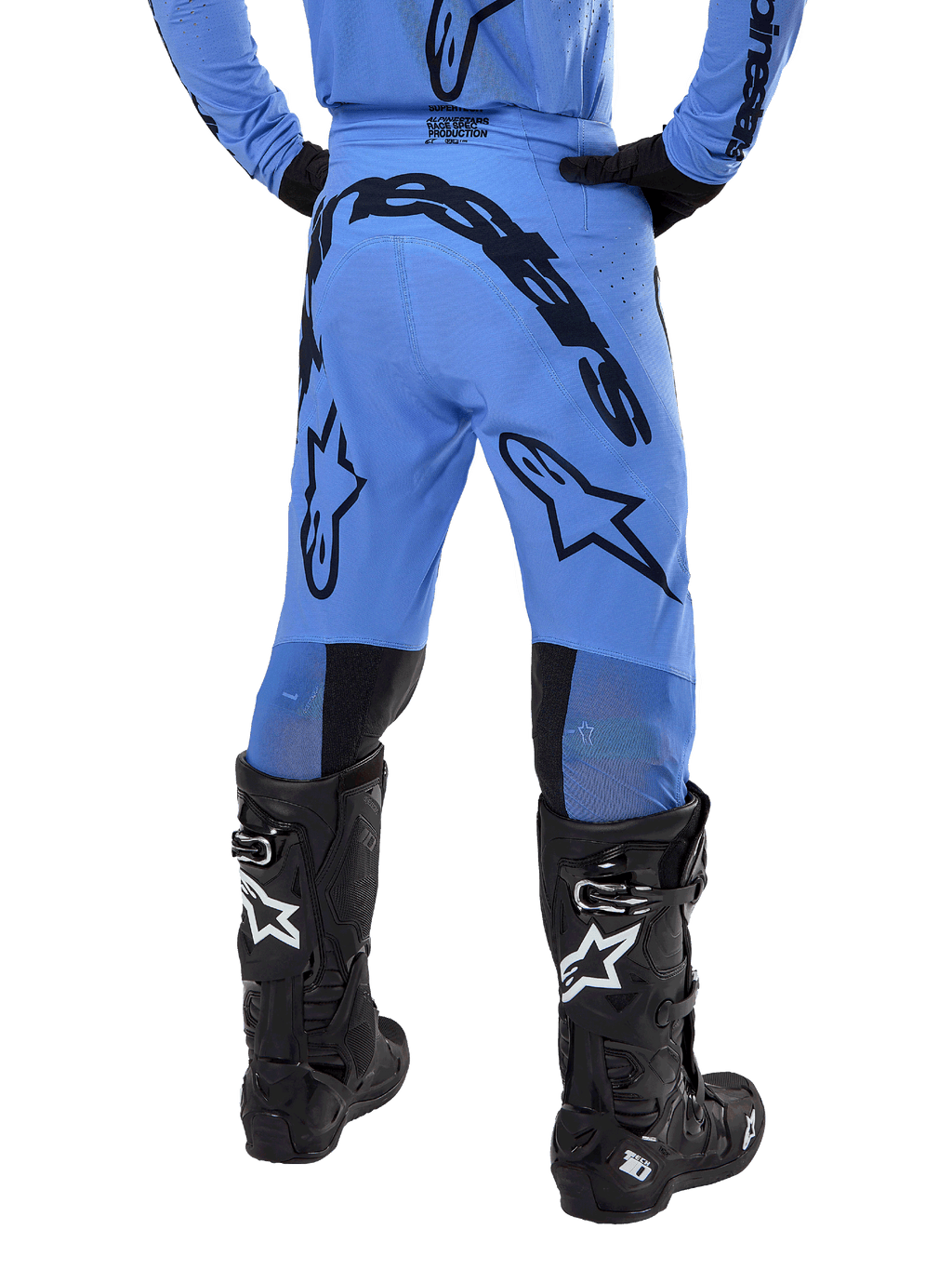 Alpinestars 2024 Supertech Dade crossbroek, motorcross broek, lichtblauw, achteraanzicht met grote zwarte branding op het zitvlak en de benen, gedragen met zwarte Alpinestars Tech 10 laarzen, atletische racepasvorm voor professionele off-road prestaties