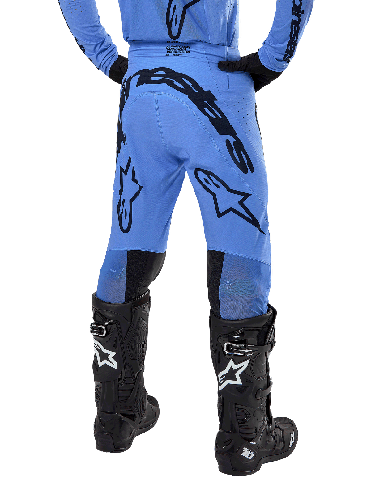 Alpinestars 2024 Supertech Dade crossbroek, motorcross broek, lichtblauw, achteraanzicht met grote zwarte branding op het zitvlak en de benen, gedragen met zwarte Alpinestars Tech 10 laarzen, atletische racepasvorm voor professionele off-road prestaties
