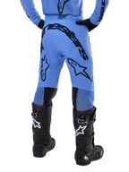 Alpinestars 2024 Supertech Dade crossbroek, motorcross broek, lichtblauw, achteraanzicht met grote zwarte branding op het zitvlak en de benen, gedragen met zwarte Alpinestars Tech 10 laarzen, atletische racepasvorm voor professionele off-road prestaties