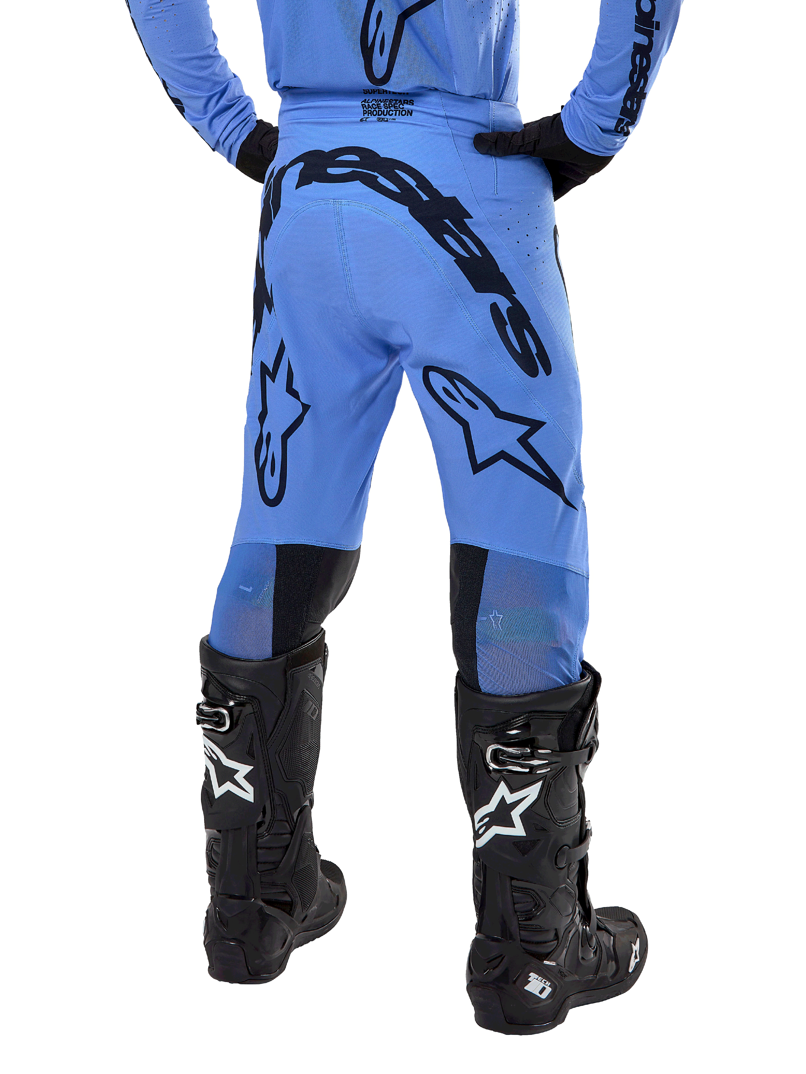 Alpinestars 2024 Supertech Dade crossbroek, motorcross broek, lichtblauw, achteraanzicht met grote zwarte branding op het zitvlak en de benen, gedragen met zwarte Alpinestars Tech 10 laarzen, atletische racepasvorm voor professionele off-road prestaties