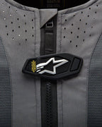 Alpinestars Tech-Air 5 Systeem detail, magnetische flap met wit sterlogo op grijze geperforeerde stof.