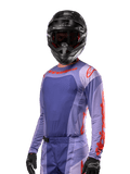 Alpinestars 2024 Techstar Ocuri Jersey, motorcross raceshirt, paars en feloranje, lange mouwen met lasergesneden perforaties voor ventilatie, atletische racepasvorm, gedragen met zwarte motorcrosshelm en handschoenen