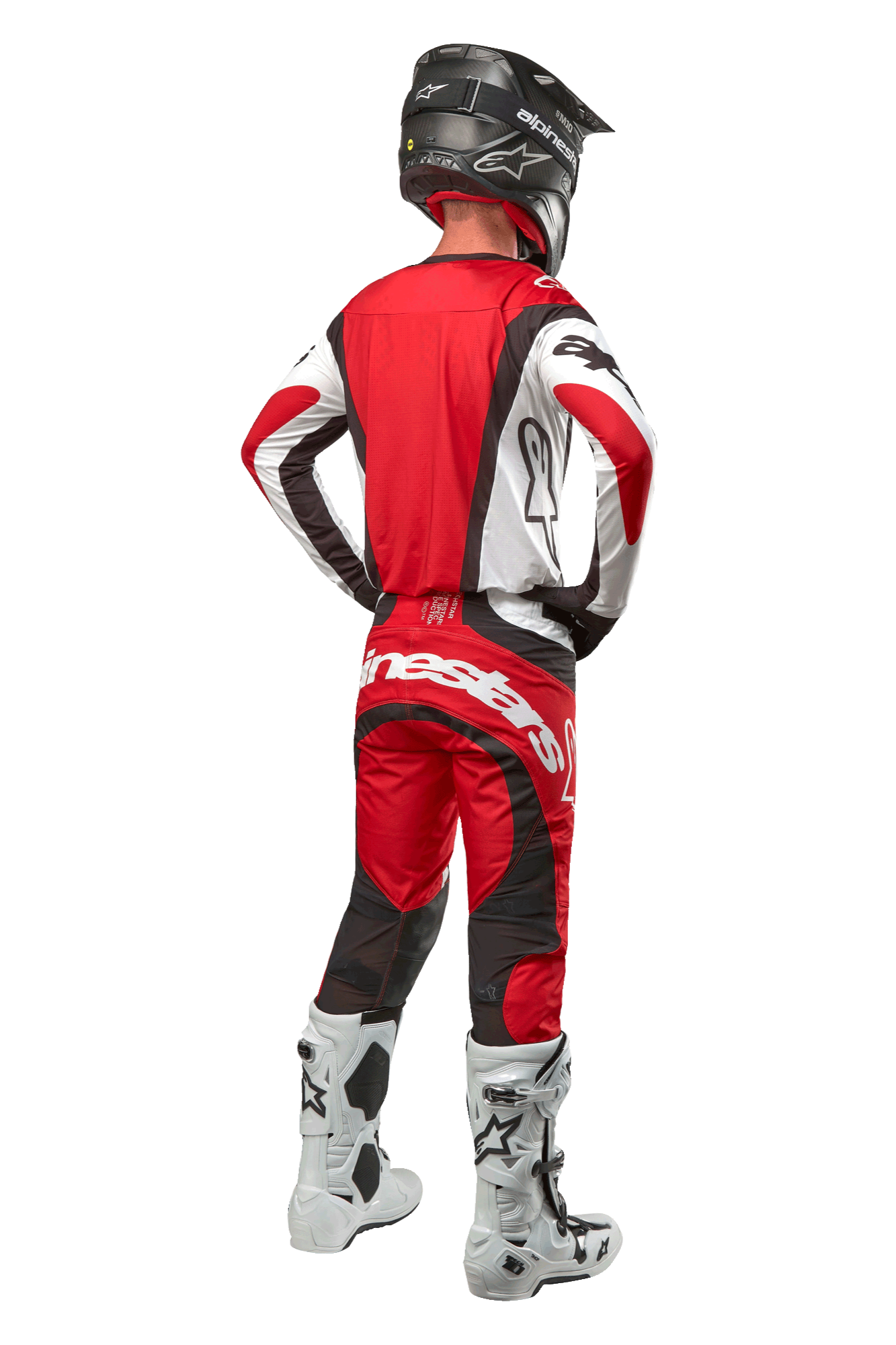 Alpinestars 2024 Techstar Ocuri broek, motorcrossbroek, Mars rood wit zwart, achteraanzicht van een motorcrosser in volledige race-uitrusting, inclusief bijpassende jersey, zwarte helm en wit-zwarte laarzen, met de nadruk op de Alpinestars-branding en duurzame materiaalconstructie.