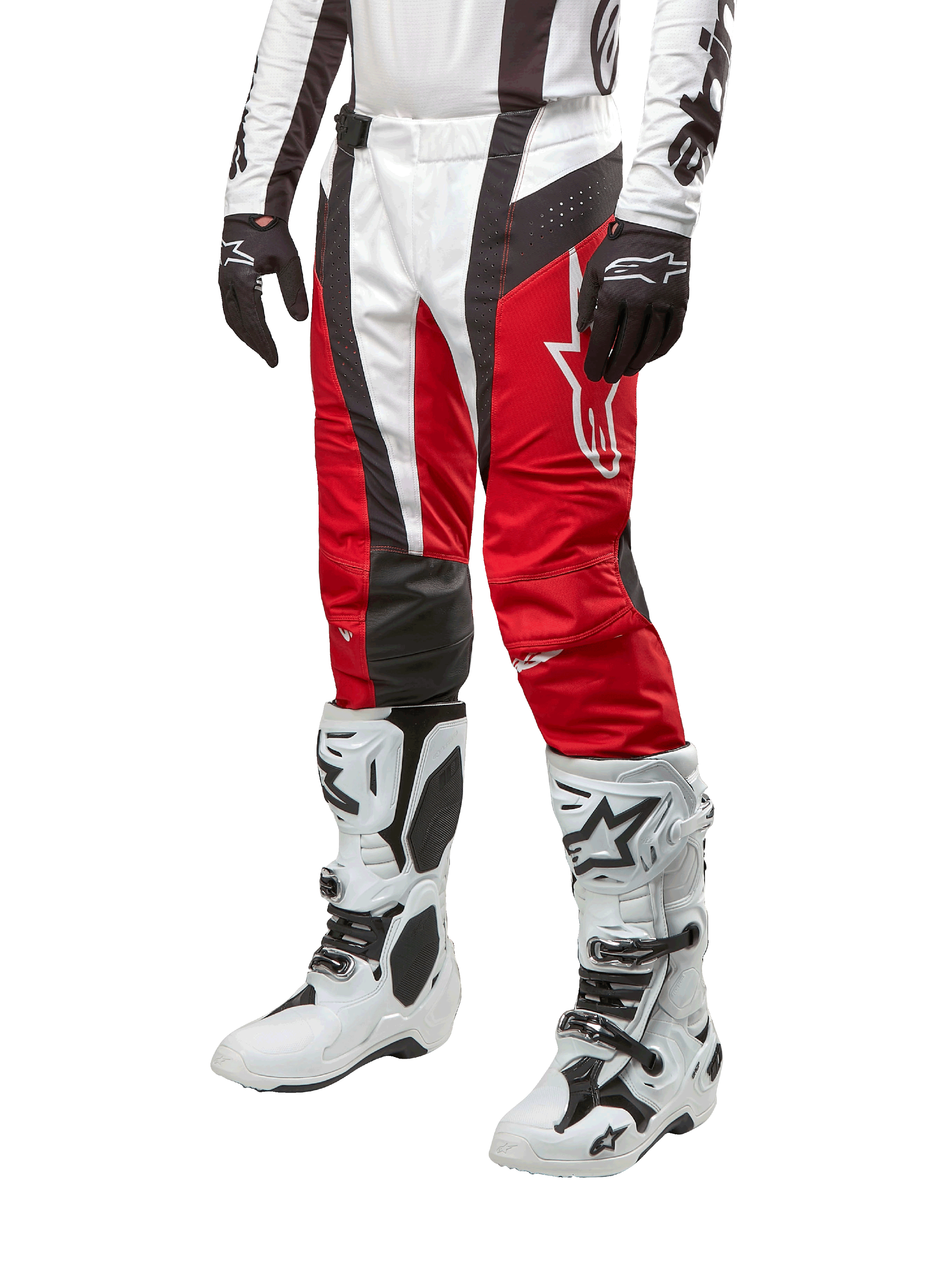 Alpinestars 2024 Techstar Ocuri crossbroek, motorcross broek, Mars rood, wit en zwart, gedragen met bijpassende wit-zwarte jersey, zwarte handschoenen en witte motorlaarzen met gespen, technische beschermende uitrusting op een witte achtergrond