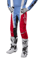 Alpinestars 2024 Techstar Ocuri broek, motorcross broek, lichtblauw, marsrood en wit, gedragen met lichtblauw shirt en witte laarzen, met het ster-logo op de dij en verstevigde knieën, complete off-road race-uitrusting