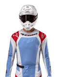Alpinestars 2024 Techstar Ocuri Jersey, motorcross shirt, lichtblauw met rood en wit, vooraanzicht met laser-gesneden ventilatie en atletische pasvorm, gedragen met een witte helm en crossbril voor een professionele off-road racing look