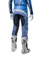 Alpinestars 2024 Techstar Pneuma crossbroek, motorcross broek, donkerblauw en lichtblauw, achteraanzicht met opvallende witte branding op het zitvlak en versterkte zwarte panelen, gecombineerd met witte Tech 10 motorcrosslaarzen