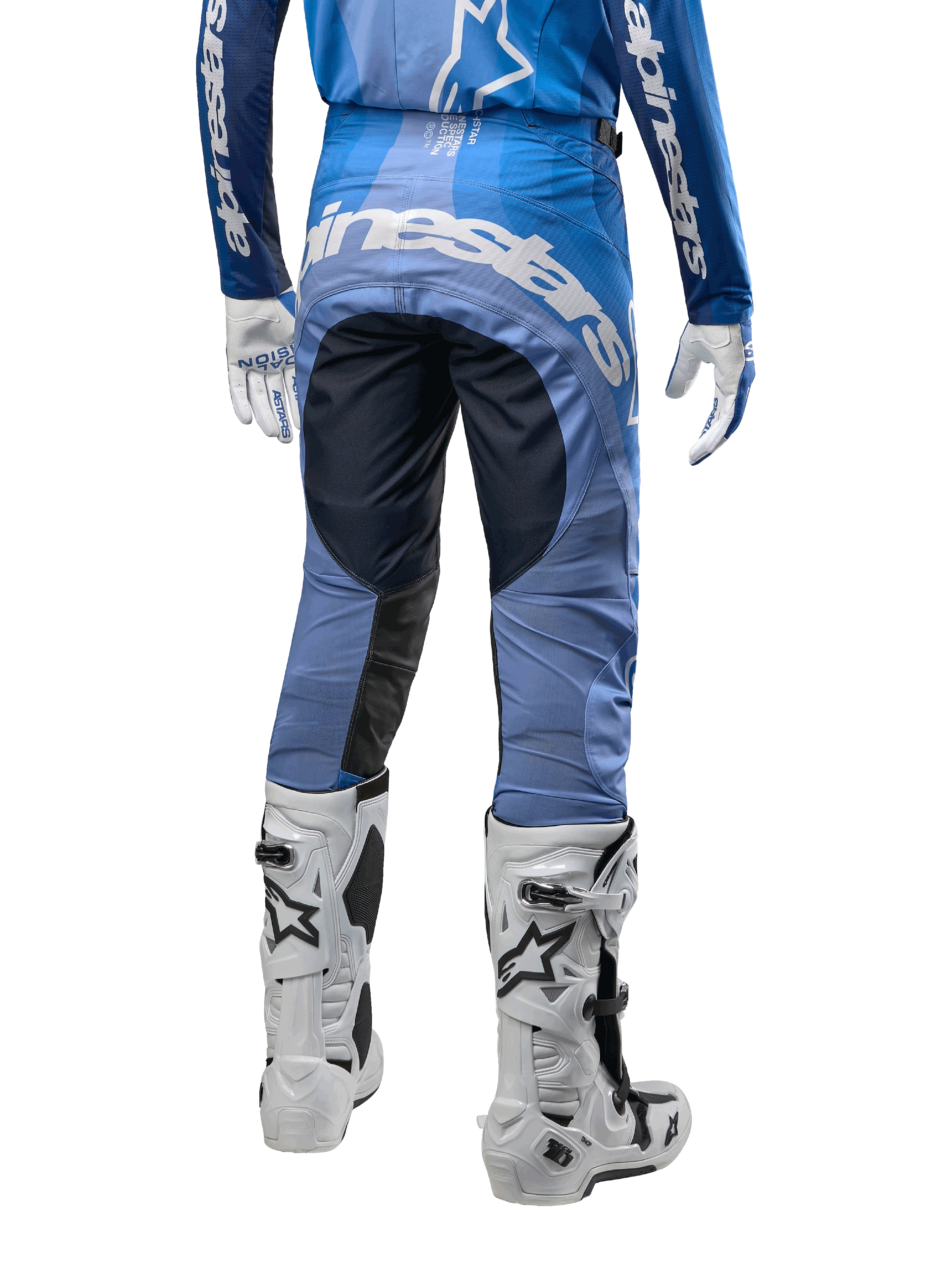 Alpinestars 2024 Techstar Pneuma crossbroek, motorcross broek, donkerblauw en lichtblauw, achteraanzicht met opvallende witte branding op het zitvlak en versterkte zwarte panelen, gecombineerd met witte Tech 10 motorcrosslaarzen