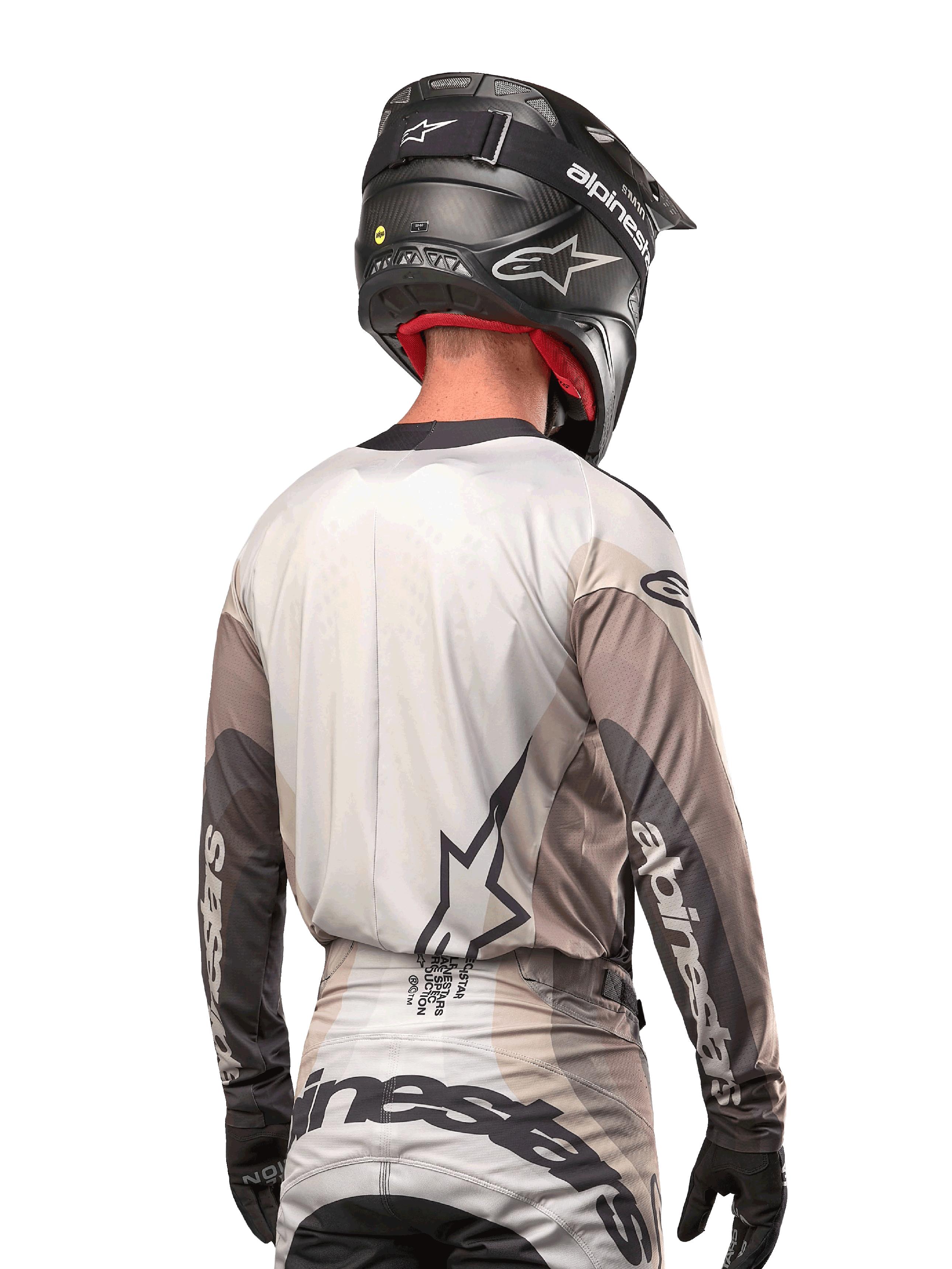 Alpinestars 2024 Techstar Pneuma Jersey, motocross shirt rugaanzicht, kleur Dark Sand Iron Dust Gray, zwarte helm met carbon-afwerking, groot sterlogo op de rug en Alpinestars-branding op de mouwen