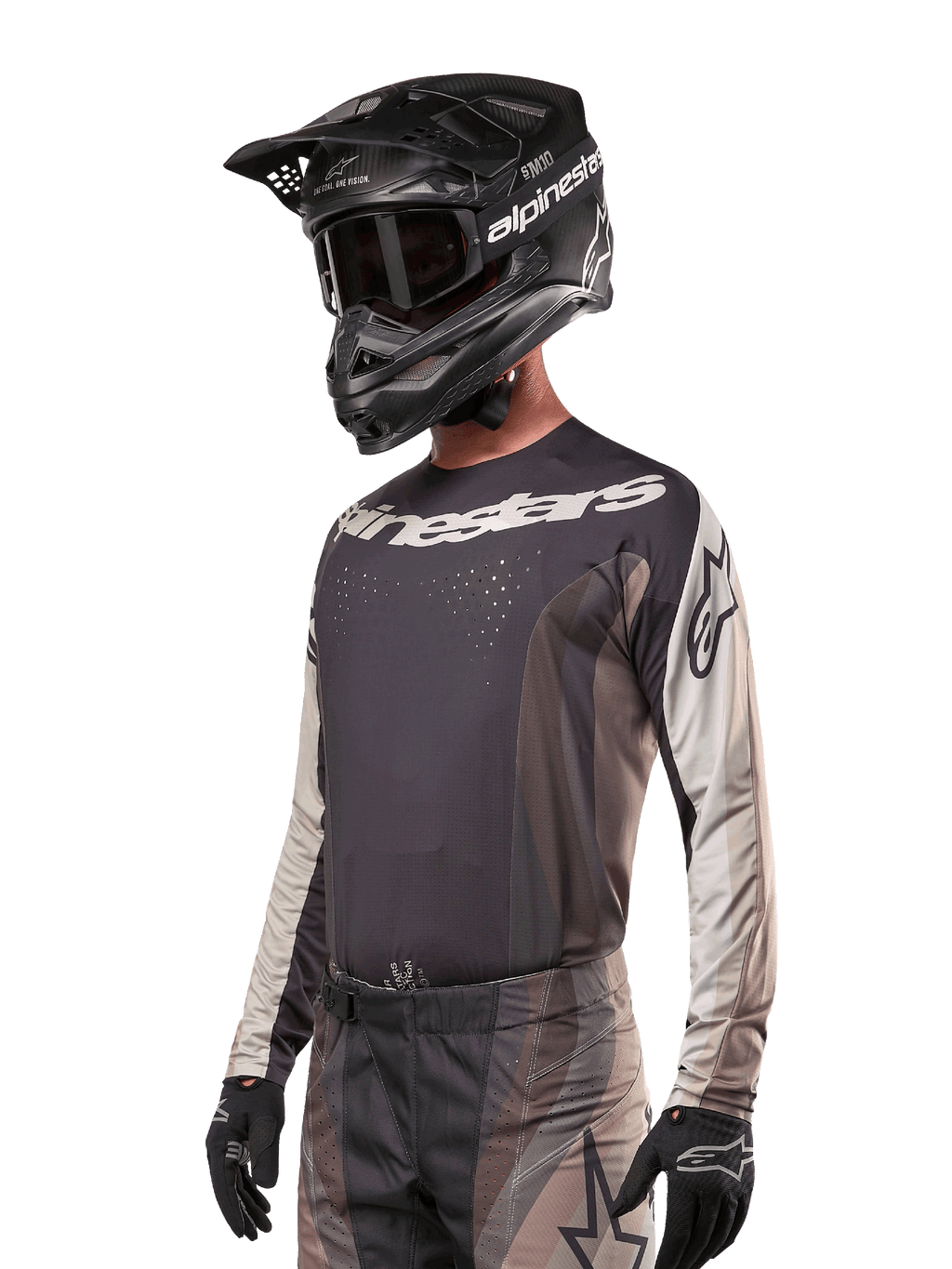 Alpinestars 2024 Techstar Pneuma Jersey, motorcross raceshirt, Dark Sand en Iron Dust grijs, performance top met lange mouwen met lasergesneden perforaties en witte logo's, gedragen met bijpassende broek en zwarte helm, atletische pasvorm voor off-road rijden.