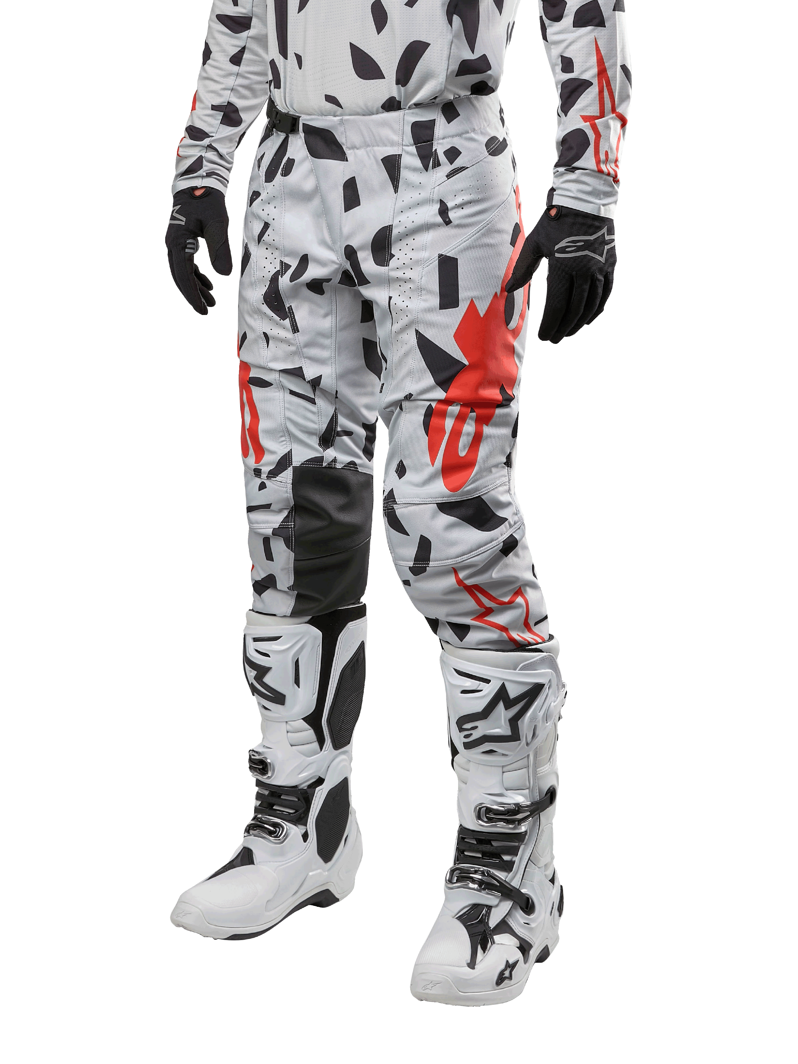 Alpinestars 2024 Techstar Rantera crossbroek, motorcross broek, Haze Gray Camo met zwart en rood abstract patroon, gedragen met bijpassende jersey, zwarte handschoenen en witte motorcrosslaarzen, ontworpen voor high-performance off-road racen