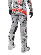Alpinestars 2024 Techstar Rantera Pants, motorcross broek, Haze Gray Camo, met zwarte camouflagepatronen en een groot rood Alpinestars-logo op het zitvlak, achteraanzicht gedragen met witte laarzen en bijpassende race-uitrusting