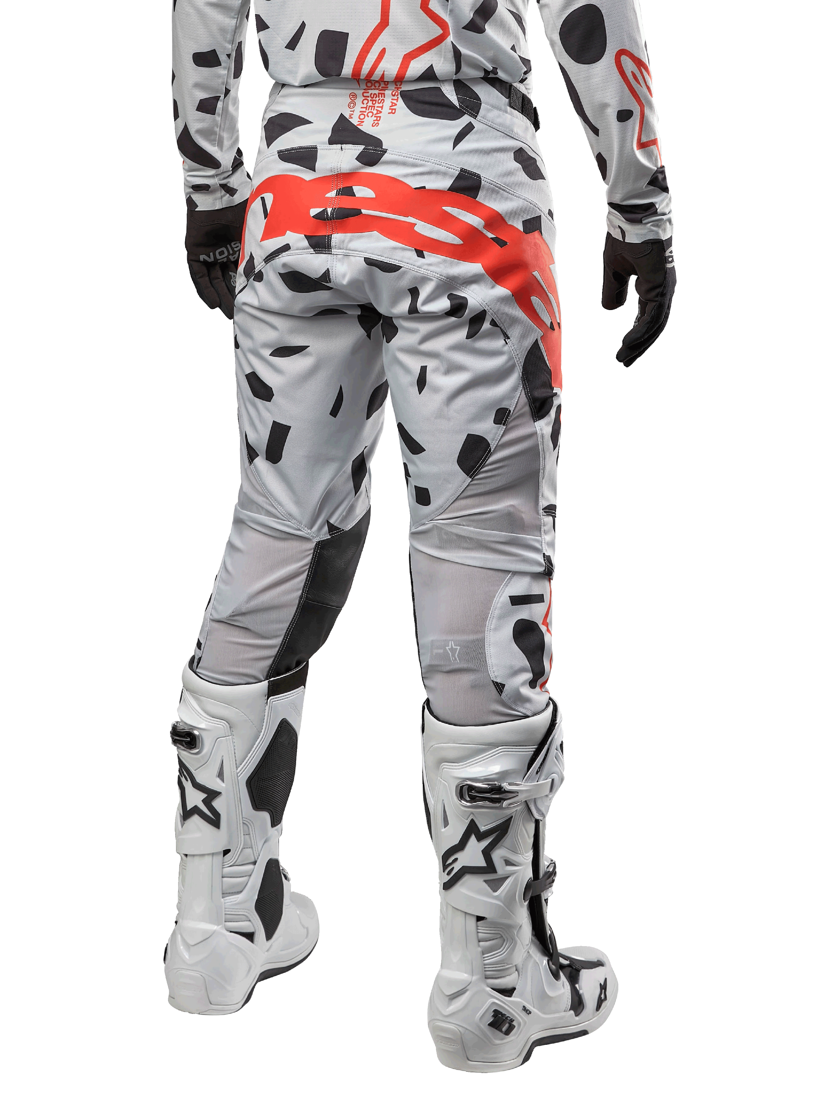 Alpinestars 2024 Techstar Rantera Pants, motorcross broek, Haze Gray Camo, met zwarte camouflagepatronen en een groot rood Alpinestars-logo op het zitvlak, achteraanzicht gedragen met witte laarzen en bijpassende race-uitrusting