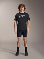 Alpinestars A-Dura Liner Shorts, zwarte fiets-binnenbroek, gedragen door een model met een zwart Alpinestars t-shirt met logo en zwarte fietsschoenen, nauwsluitend ontwerp voor MTB-prestaties en comfort in het zadel.