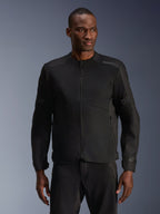 Mannelijk model draagt Alpinestars C-1 Air Jacket in het zwart, eigentijdse motorjas met uitgebreide tech mesh-panelen en een volledige ritssluiting aan de voorzijde, gecombineerd met bijpassende zwarte motorbroek, urban lifestyle en woon-werkverkeer uitstraling