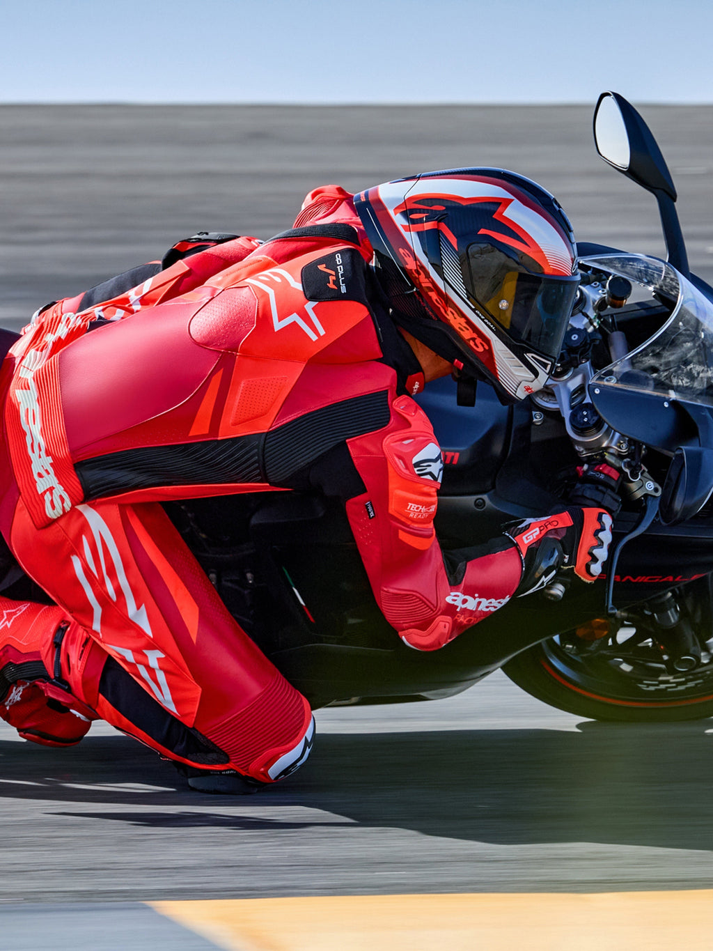 Alpinestars GP Plus V4 Sprint eendelig leren pak, rood en wit, Tech-Air ready motorracepak op rijder in een circuitbocht.
