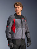 Alpinestars St-2 Air Jacket, motorjas, diepgrijs en donkergrijs met felrode accenten, voorzien van grote mesh-ventilatiepanelen, lasergeperforeerde details en rood sterlogo, gedragen door een model in een studio-omgeving, moderne adventure touring-stijl
