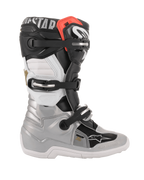 Alpinestars Youth Tech 7S laarzen, motorcrosslaarzen, zwart, zilver, wit en goud, zijaanzicht met zilveren onderste schaal, zwarte en witte bovenpanelen, rood accent aan de bovenrand en een sluitingssysteem met drie gespen
