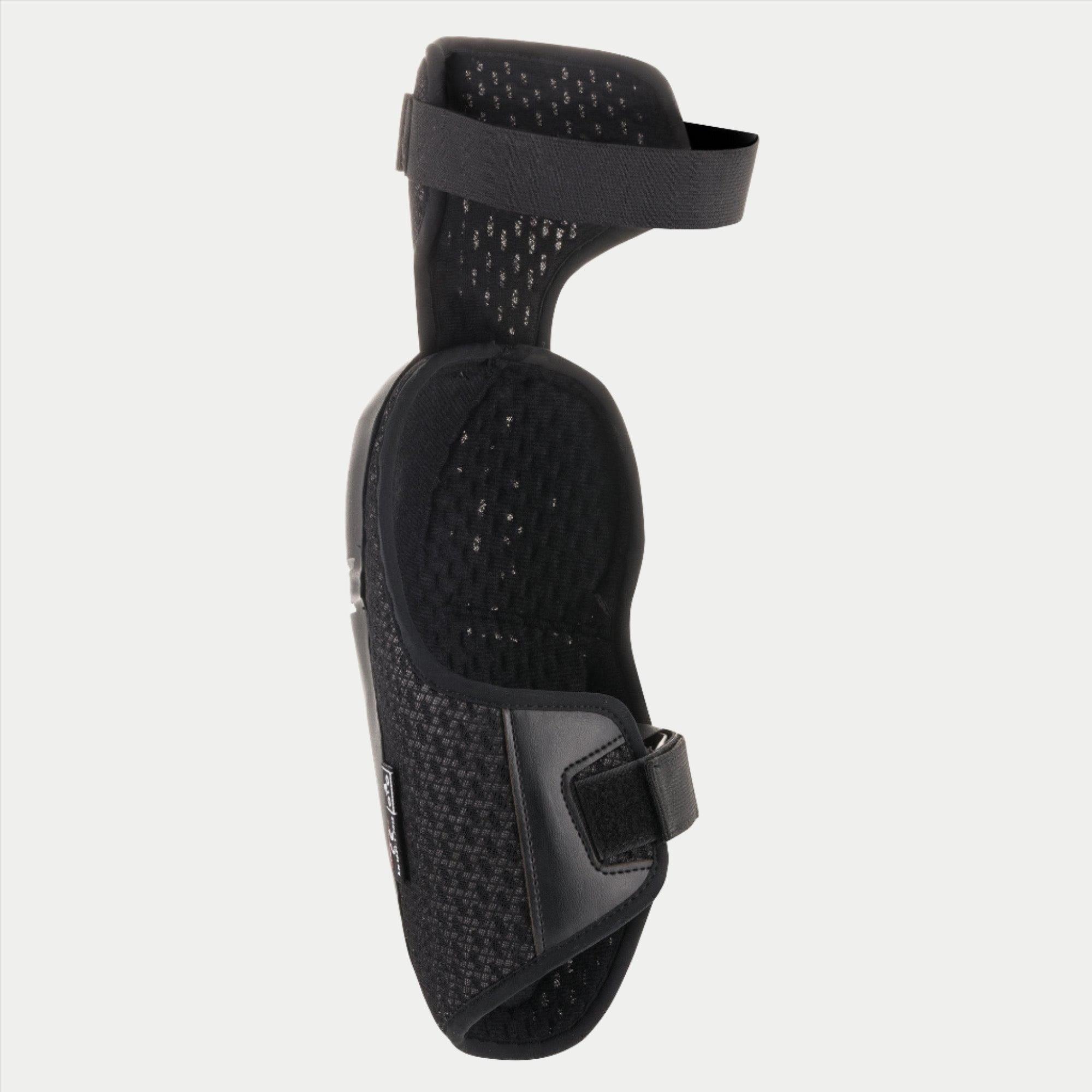 Alpinestars Youth Bionic Plus Knee Protector, Black, showing the interior mesh lining and dual strap closure system, ergonomic design for off-road motocross protection